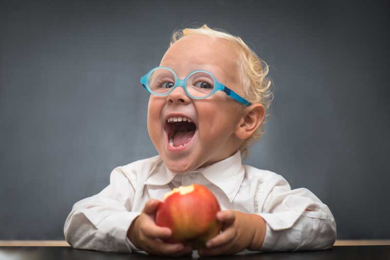 kleiner Bub mit Apfel und Brille